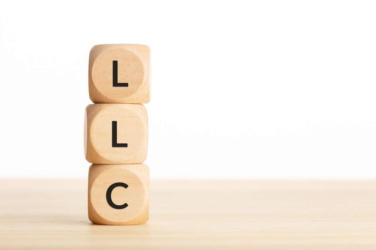 LLC or Limited Liability Company concept. Tex on wooden blocks on table. Copy space