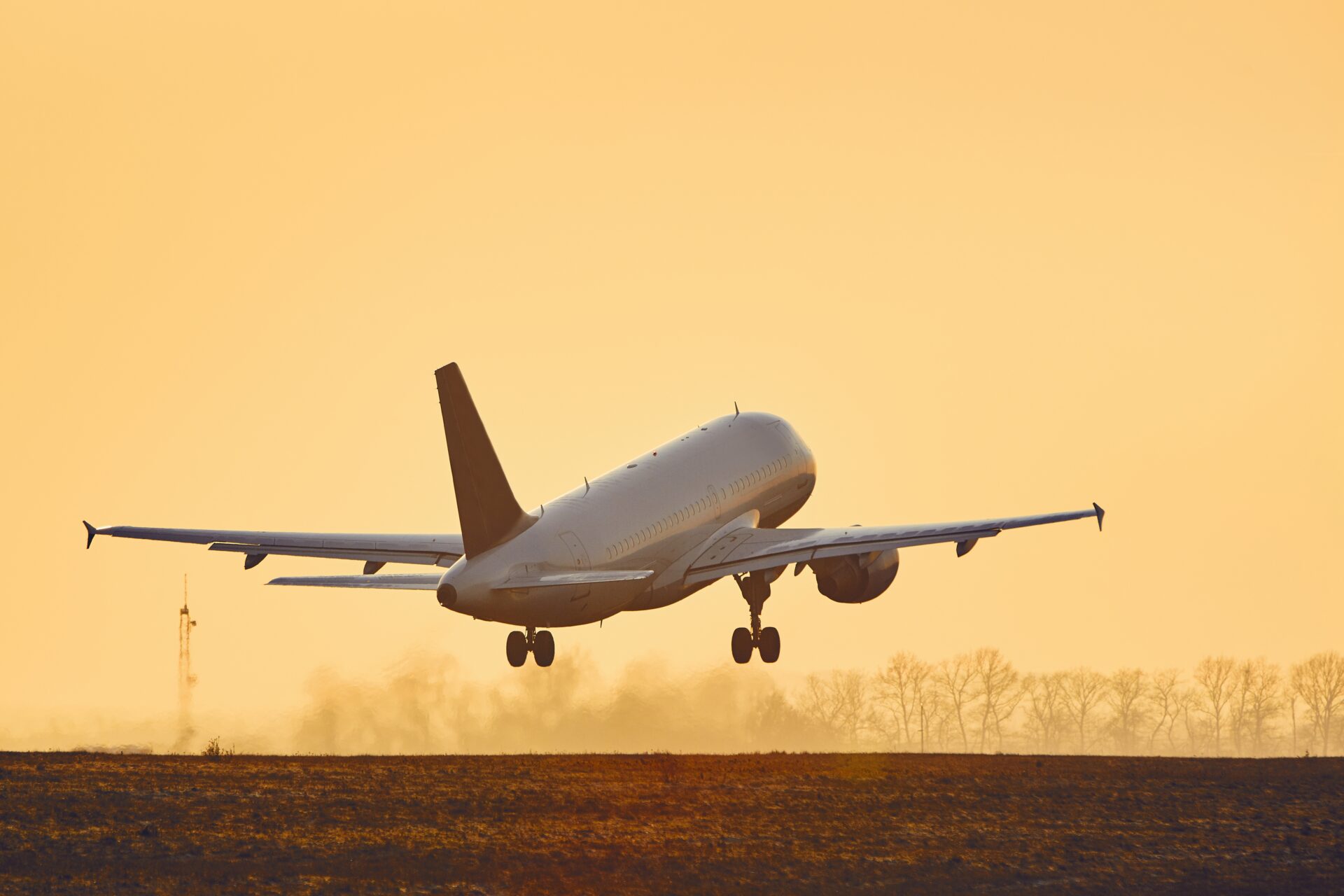 Airplane taking off at sunset